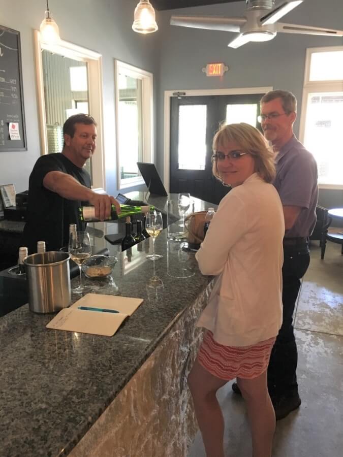 Steve Newsom serving Trilogy Cellars wines to Laurie and Shelly Ware